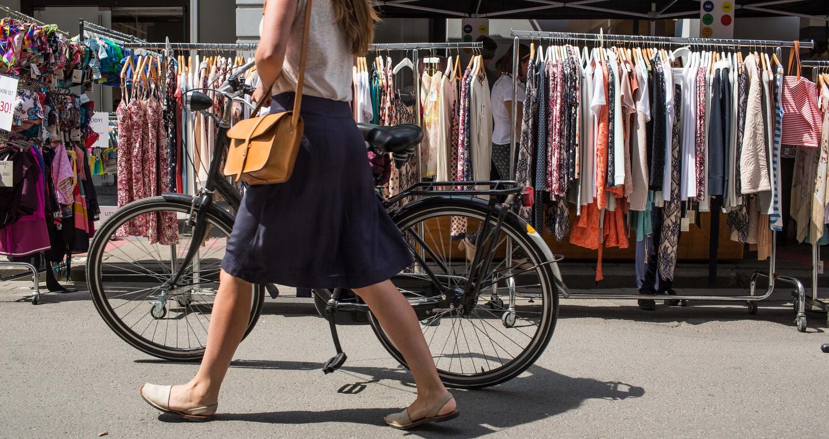 A woman walks past a shop during a braderie