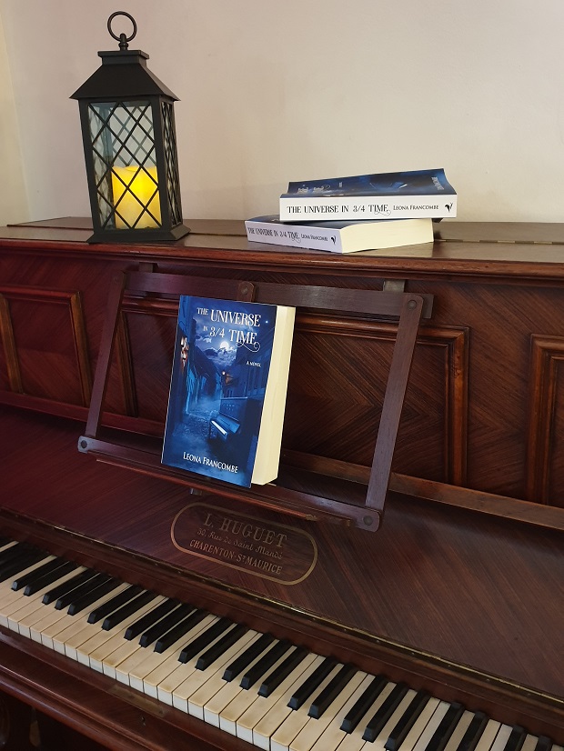 Rosewood piano with book The Universe in 3/4 Time