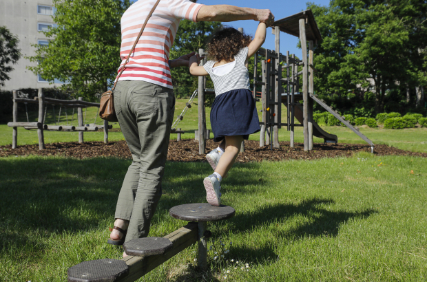Illustration picture shows an adult holding a girl playing in a playground in Brussels, Wednesday 27 May 2020. Many parents had to take time off or find alternative childcare during the first wave of the coronavirus crisis when the schools were closed. (BELGA PHOTO THIERRY ROGE)