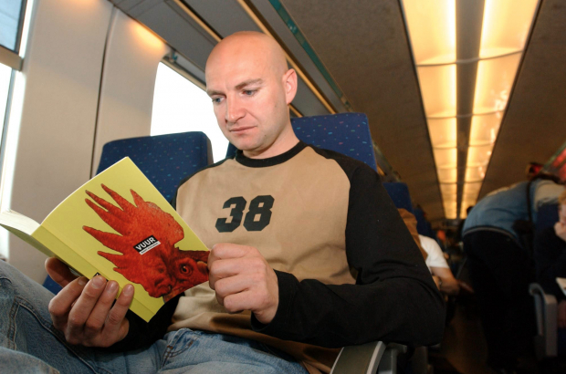 A man reads the book "het Vuur" by Bart Koubaa in the Oostende-Brussels train. (BELGA PHOTO LIEVEN VAN ASSCHE)