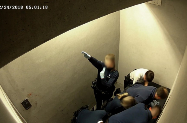 A Belgian police officer gives a Nazi salute while Jozef Chovanec is restrained in the holding cell at Charleroi Airport, Feb. 24, 2018 (©YouTube/Belgian Police)