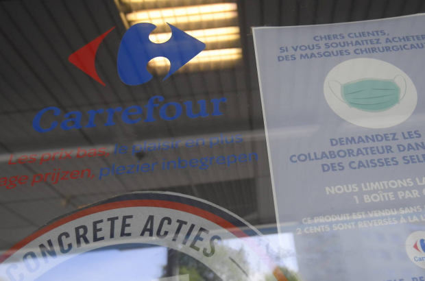 The Carrefour logo and a compulsory face mask announcement are seen on the entrance to a Carrefour supermarket in Brussels (BELGA PHOTO LAURIE DIEFFEMBACQ)