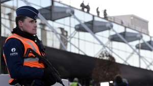Armed police stand on guard at the departure hall of Brussels airport in Zaventem. (BELGA PHOTO POOL DIDIER LEBRUN)