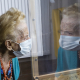 An old lady looks through a perspex screen installed at her care home in Brussels, Belgium (BELGA PHOTO)